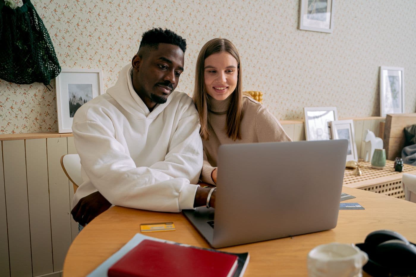 A couple smiling together at a laptop during their online wedding ceremony